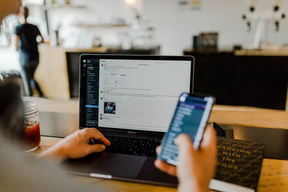 Person working on a phone and laptop