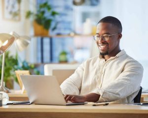 Man smiling while working on a computer