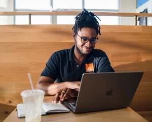UTSA Online student sitting at a coffee shop with his iPad doing some school work.